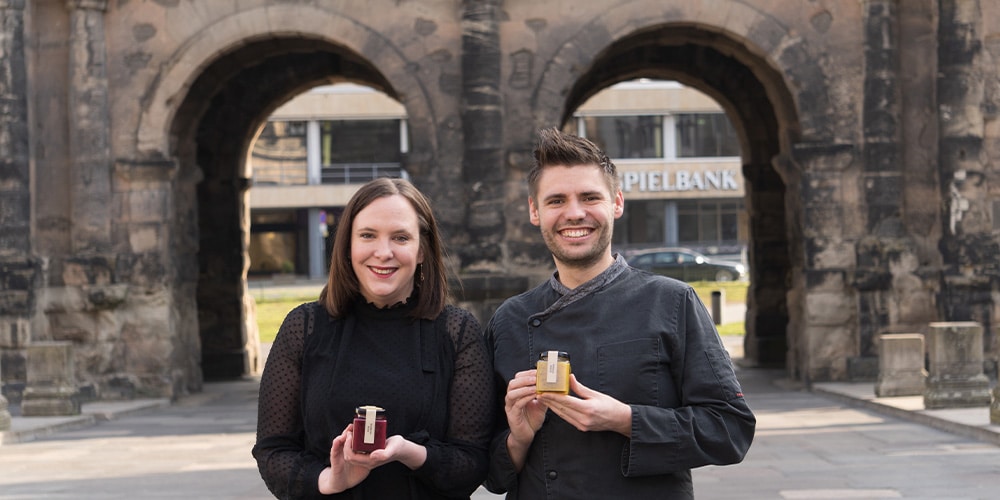 Vanessa und Jozsef von Kaldis Gourmet mit Fruchtaufstrichen vor der Porta Nigra in Trier