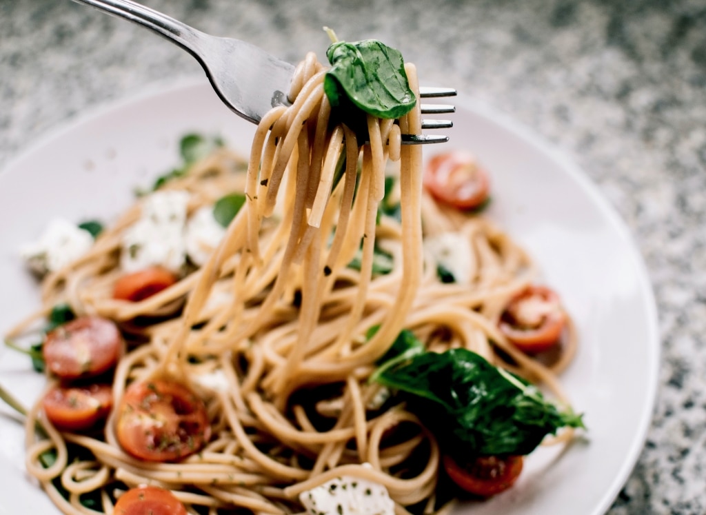 Spaghetti mit Spinat, Tomaten und Traubenkernöl auf dem Teller