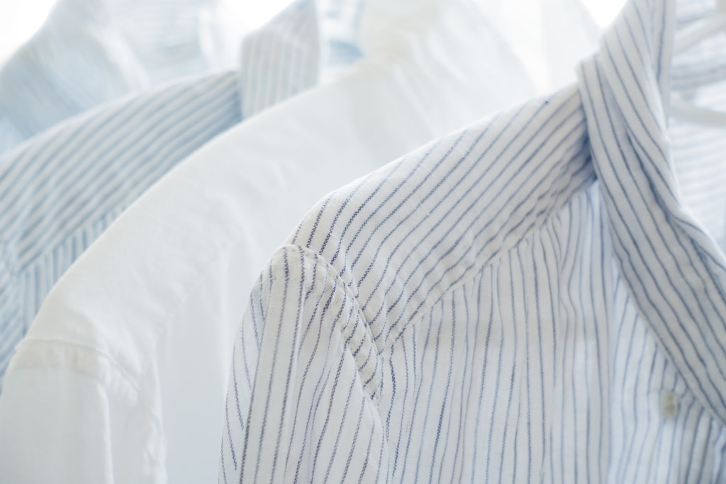Aufgehängte Männerhemden weiß und weiß-blau gestreift