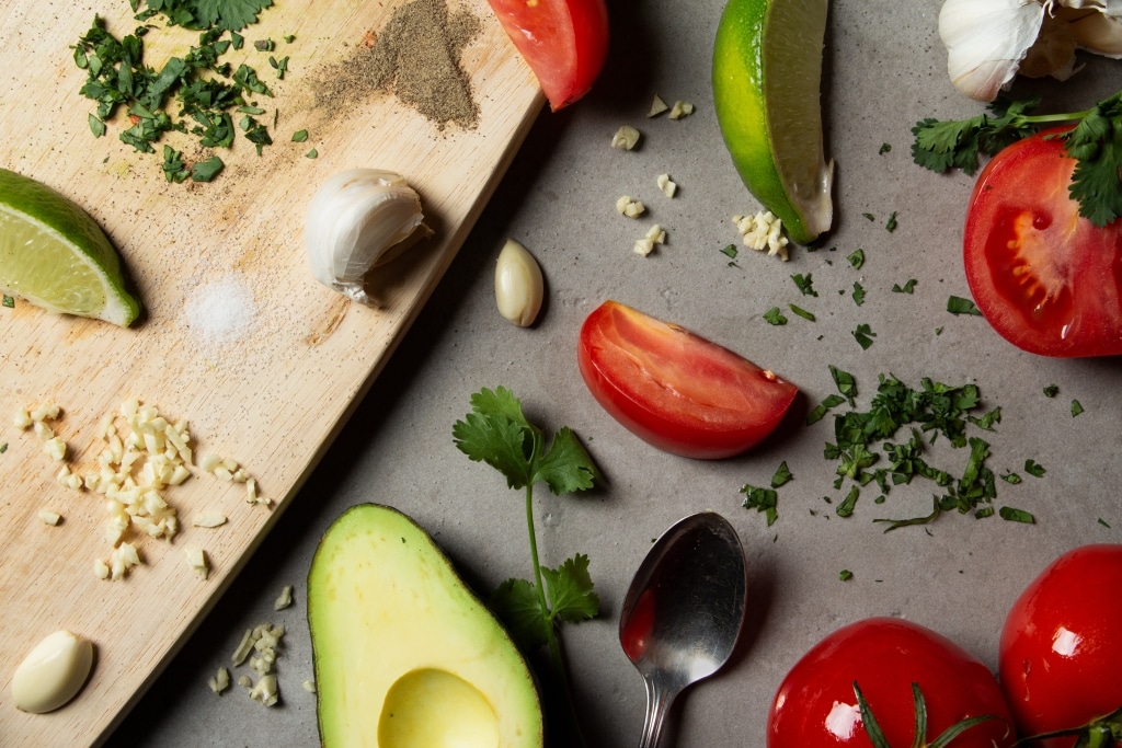 Die klassischen Zutaten einer Guacamole: Avocados, Knoblauch, Limetten, Tomaten und Koriander