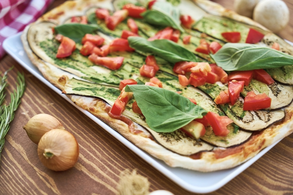 Pizza mit Aubergine, Paprika und frischen Oregano-Blättern